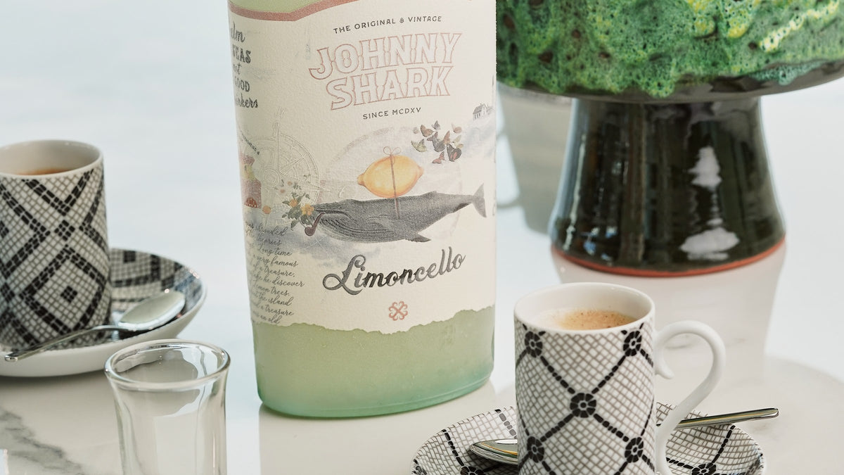 Mesa de almoço com garrafa de limoncello Johnny Shark e chávenas de café